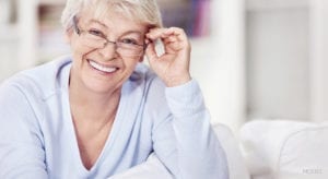 Mature Female smiling and touching her glasses