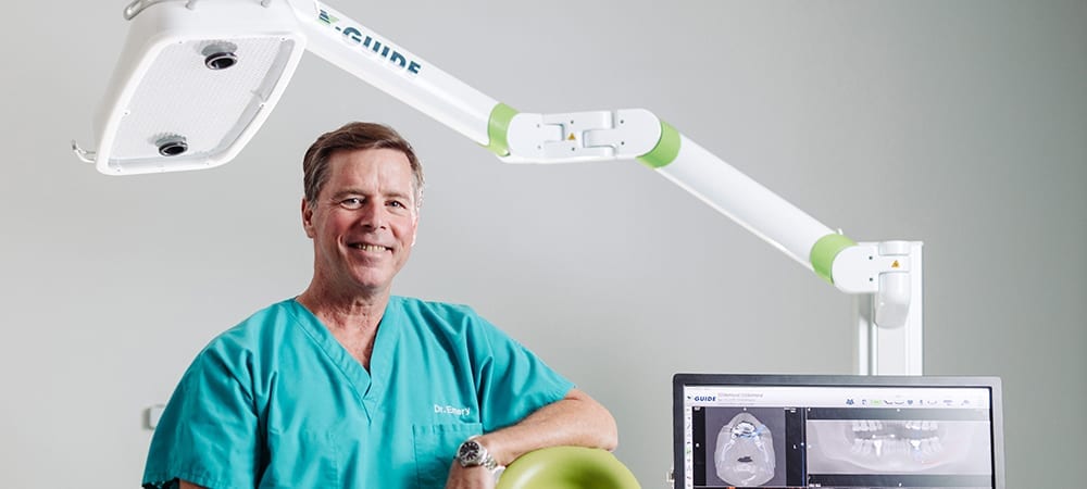 Dr. Emery Smiling In Front of X-Guide Machine