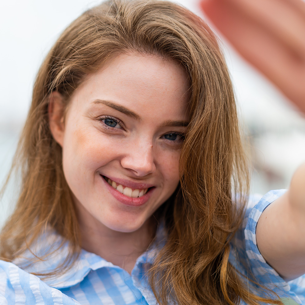 Young woman framing her face with her hands
